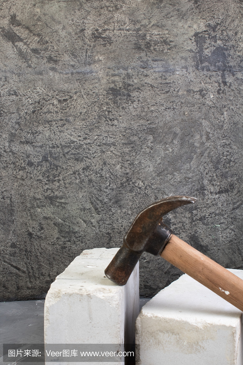 砖,锤在灰色的混凝土背景上。副本的空间。俯视图